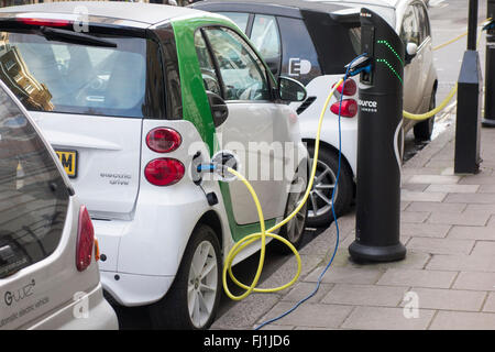 Elektrofahrzeuge eingesteckt Ladestationen auf einer Straße in London, Großbritannien Stockfoto