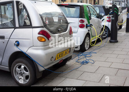 Elektrofahrzeuge eingesteckt Ladestationen auf einer Straße in London, Großbritannien Stockfoto