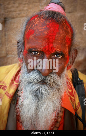 Hinduistische heilige Mann sadhu mit Gesicht durch rote Pulver in Jaisalmer, Indien abgedeckt Stockfoto