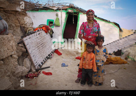 Eine Frau steht mit ihren Kindern vor ihrem Haus in Jaisalmer, Indien Stockfoto