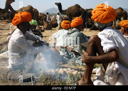 Männer mit orangefarbenen Turban sammeln während der pushkar Kamel fait, Indien Stockfoto