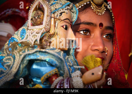 Junge Rajasthani Mädchen mit Puppe Während Gangaur Festival in Udaipur, Indien Stockfoto