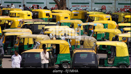 Parken von gelben und grünen Rikschas/Taxi/Kabinen in Delhi, Indien Stockfoto