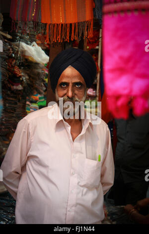 Sikh mann Verkauf von Kleidung im Shop in Delhi, Indien