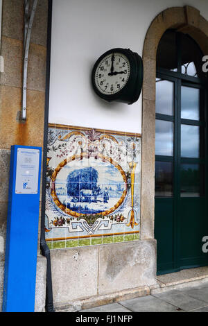 Keramische Fliesen oder Azulejos an Wand des Bahnhofs neben Ankündigungen Lautsprecher, Caminha, Provinz Minho, Nordportugal Stockfoto