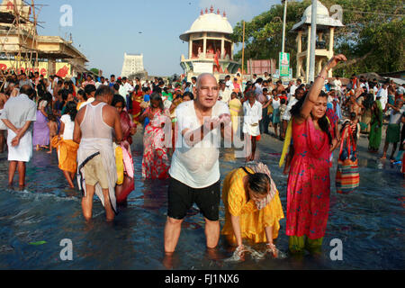 Pilger sind Puja am frühen Morgen, im heiligen Wasser des Ozeans in der Nähe der heiligen Stadt Rameswaram, Tamil Nadu, Indien Stockfoto