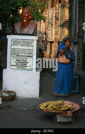 Eine Frau steht in der Nähe der Statue von Rabindranath Tagore in der Sudder Street in der Innenstadt von Kolkata, Indien Stockfoto