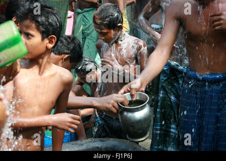 Kinder waschen sich in den frühen Morgen im öffentlichen Duschen in der Mitte von Kolkata, Indien Stockfoto