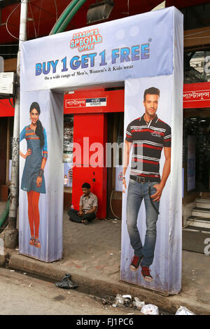 Einsamer Mann sitzt allein vor einem Bekleidungsgeschäft in neuen Marktgebiet, Kolkata, Indien Stockfoto