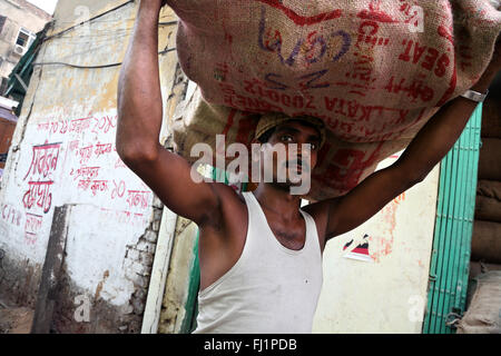 Arbeitnehmer trägt große schwere Tasche in Howrah, Kolkata, Indien Stockfoto