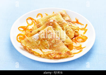 Pfannkuchen mit orange Sirup auf weißen Teller Stockfoto