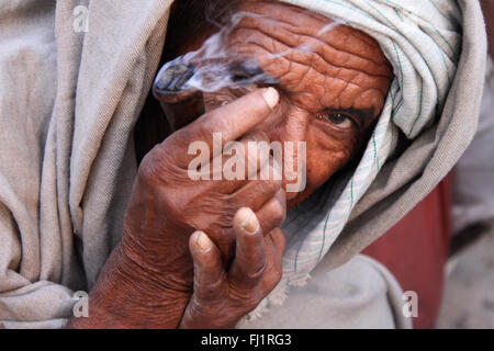 Ein Pilger mit Turban ist Rauchen chillum Pipe in der Masse während Kumbh mela in Haridwar Stockfoto