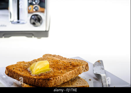 Vier Stück, chrom Toaster mit Toast und Butter. Stockfoto