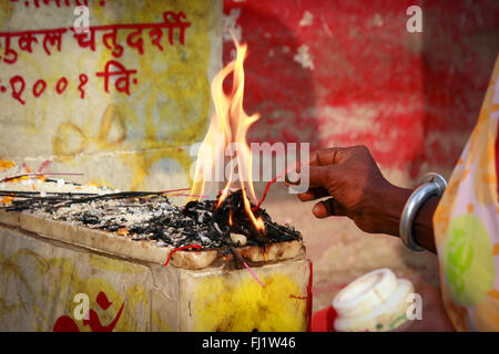 Hand der Frau tun puja Ritual, das auf einem Ghat in Varanasi, Indien Stockfoto