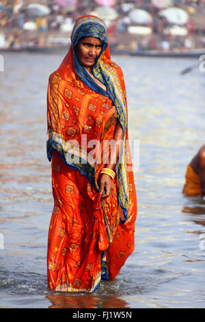 Indisch-hinduistischen Frau mit traditionellen saree Spaziergänge in das Wasser des heiligen Ganges in Varanasi, Indien Stockfoto