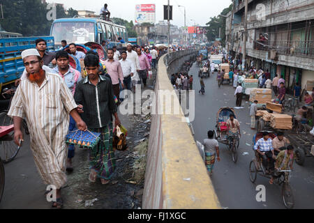 Menschen gehen in einem belebten und verkehrsreichen Straße von Dhaka, Bangladesch - Landschaft Stockfoto