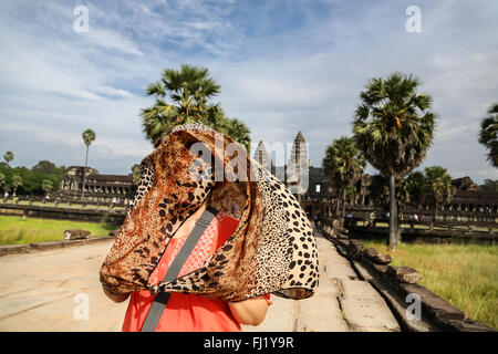 Touristische unter einem Jaguar Muster Schal vor Angkor Vat, Kambodscha ausgeblendet Stockfoto