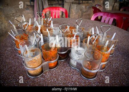 Gewürze und Chili peppers in Gläsern auf einem Tisch in einem Restaurant von Kampot, Kambodscha Stockfoto