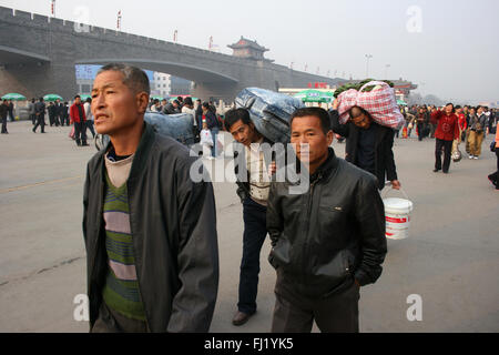 Männer Passagiere zu Fuß in der Nähe von einem Bahnhof der Xi'an, China Stockfoto