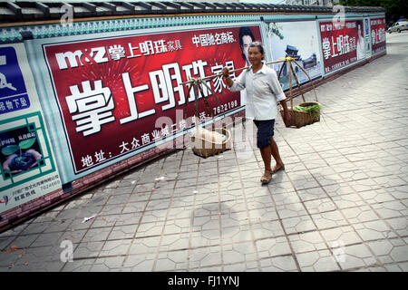 Frau Anbieter zwei Körbe in einer Straße von Jianshui, China Stockfoto
