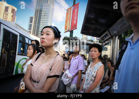 Leute für den Bus in einer Straße von Shanghai, China warten Stockfoto