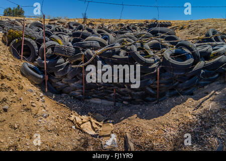 Ein Haufen von ausrangierten Auto Reifen sitzen gegen einen Stacheldrahtzaun in einer ländlichen Umgebung in der Central Valley in Kalifornien. Stockfoto