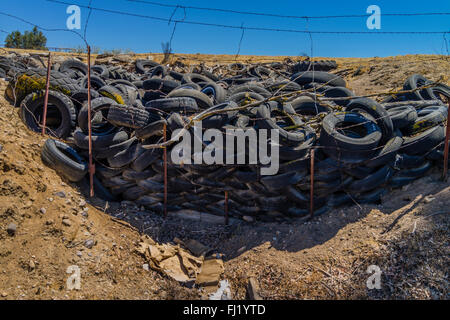 Ein Haufen von ausrangierten Auto Reifen sitzen gegen einen Stacheldrahtzaun in einer ländlichen Umgebung in der Central Valley in Kalifornien. Stockfoto