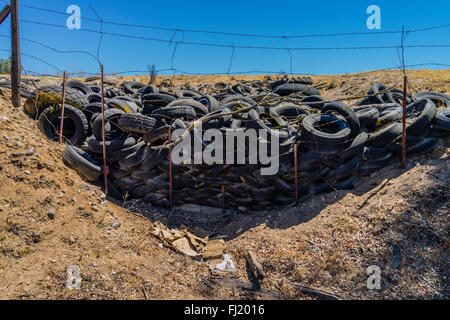 Ein Haufen von ausrangierten Auto Reifen sitzen gegen einen Stacheldrahtzaun in einer ländlichen Umgebung in der Central Valley in Kalifornien. Stockfoto