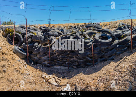 Ein Haufen von ausrangierten Auto Reifen sitzen gegen einen Stacheldrahtzaun in einer ländlichen Umgebung in der Central Valley in Kalifornien. Stockfoto