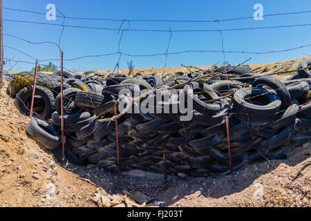 Ein Haufen von ausrangierten Auto Reifen sitzen gegen einen Stacheldrahtzaun in einer ländlichen Umgebung in der Central Valley in Kalifornien. Stockfoto