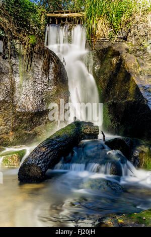 Wasser fließt durch Felsen und unter einem Maschinenbordbuch am Monte Gelato Wasserfälle im Valle del Treja regional Park, Latium, Italien Stockfoto