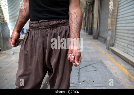 Ein Mann zeigt Tattoos auf seine Arme in der Persischen im Großen Basar von Teheran, Iran geschrieben Stockfoto