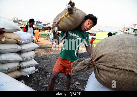 Arbeitnehmer Tragen von schweren Jute Tasche in Bagan, Myanmar, mit 'MYanmar' t-shirt Stockfoto