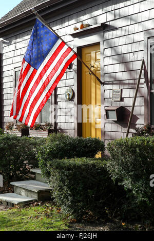 Amerikanische Flagge durch die Vordertür eines alten Hauses in South Yarmouth, Massachusetts Stockfoto