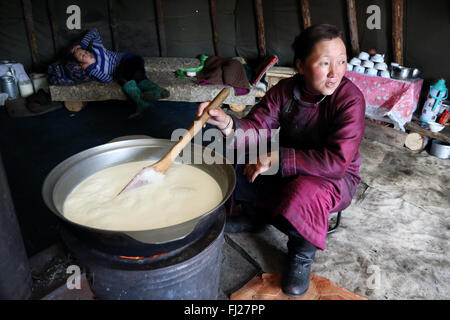 Tsaatan Frau vorbereiten Milch für den Käse, Menschen, die mit Rentier in Zentralasien Stockfoto