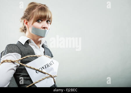 Angst, Geschäftsfrau gebunden Vertragsbedingungen und Konditionen mit Mund mit Klebeband schließen. Angst vor Frau auf Stuhl werden Slave gebunden. Stockfoto