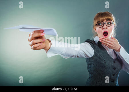 Fliegen Sie Angst Metapher, Aerophobie Konzept. Geschäftsfrau hält Flugzeug in der hand. Stockfoto