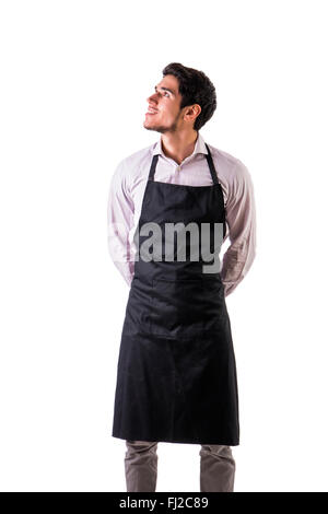 Jungkoch oder Kellner posieren, tragen schwarze Schürze und Hemd isoliert auf weißem Hintergrund auf einer Seite Stockfoto