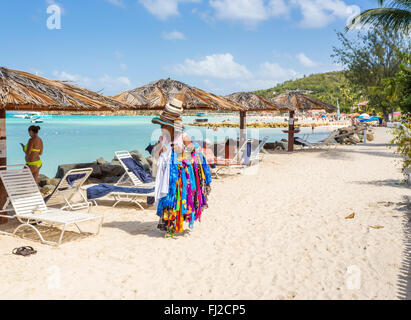 Frau verkauft Hüte und bunte Schals am Strand in Dickenson Bay, nördlich von Antigua, Antigua und Barbuda Stockfoto