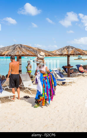 Frau verkauft Hüte und bunte Schals am Strand in Dickenson Bay, nördlich von Antigua, Antigua und Barbuda Stockfoto