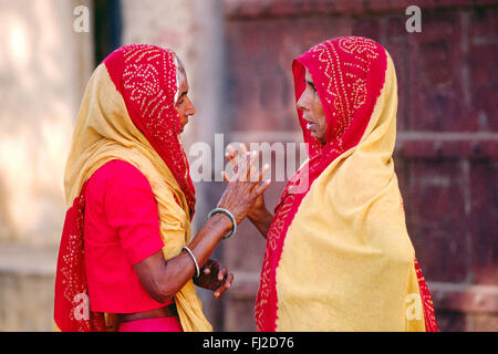 Zwei RAJASTHANI Frauen in traditionellen SARIS haben ein Gespräch in JAIPUR - RAJASTHAN, Indien Stockfoto