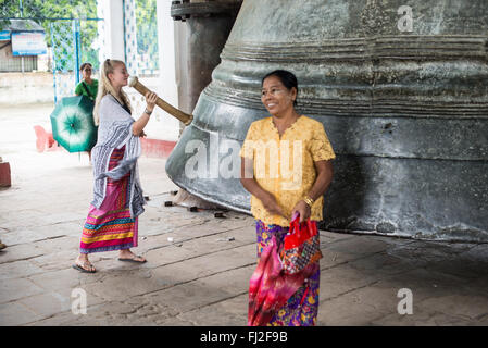 Mingun Bell Mingun Myanmar // MINGUN, Myanmar — Besucher läuten die massive Mingun Bell in ihrem traditionellen Pavillon in der Nähe von Mingun, Myanmar. Sie wurde 1808 während der Regierungszeit von König Bodawpaya gegossen und wiegt etwa 90 Tonnen und gilt weithin als die größte Glocke der Welt. Die riesige Bronzeglocke ist etwa 12 Fuß hoch und 16 Fuß Durchmesser. Die Glocke wurde Anfang des 19. Jahrhunderts als Teil der ehrgeizigen Bauprojekte König Bodawpayas in Auftrag gegeben. Am Ayeyarwady River in der Nähe von Mandalay gelegen, ist die Mingun Bell ein aktives religiöses Artefakt und ein beliebtes Reiseziel Stockfoto