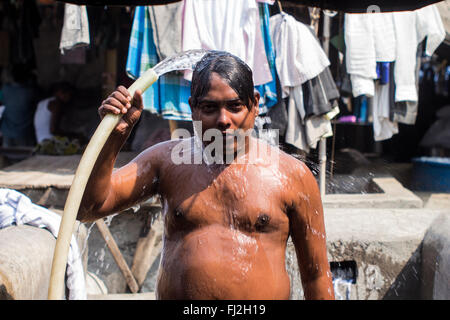 Ein Mann wäscht sich in Mahalaxmi Dhobi Ghat, die weltweit größte Washermen Kolonie in Mumbai, Indien Stockfoto