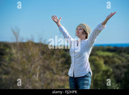 Frau mit ausgestreckten Armen in der Natur genießen Stockfoto
