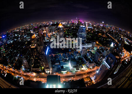 BANGKOK, Thailand – die glitzernde Skyline von Bangkok erstreckt sich unterhalb des Hotels vom Dachrestaurant Vertigo auf dem Dach des Banyan Tree Hotel aus. Wolkenkratzer und Hochhäuser beleuchten die weitläufige thailändische Hauptstadt mit unzähligen Lichtern und schaffen ein atemberaubendes Stadtpanorama. Stockfoto