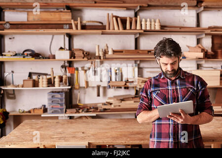 Handwerker-Schreiner im Atelier Holzarbeit mit digital-Tablette Stockfoto