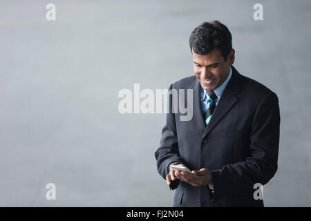 Vogelperspektive Blick auf ein indischer Geschäftsmann vor modernen Bürogebäude. Asiatische Geschäftsmann lächelnd. Stockfoto