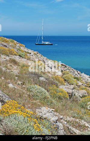 Mallorca, Balearen, Spanien: ein Segelboot und die mediterrane Macchia in Cala Torta, Fernbedienung und unbevölkerten Strand im Nordosten der Insel Stockfoto