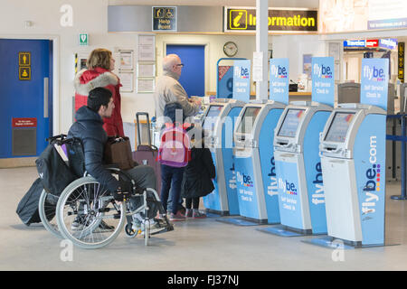 Passagiere mit Flybe self-service Check-in-Schreibtische Automaten am Exeter Flughafen, England, UK Stockfoto