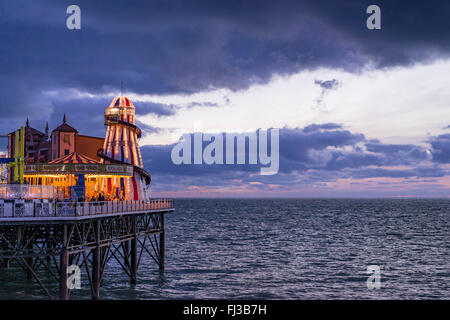 Ein Blick vom Ufer des Meeres und die Vergnügungen am Ende des Brightons Palace Pier genommen in der Abenddämmerung Stockfoto